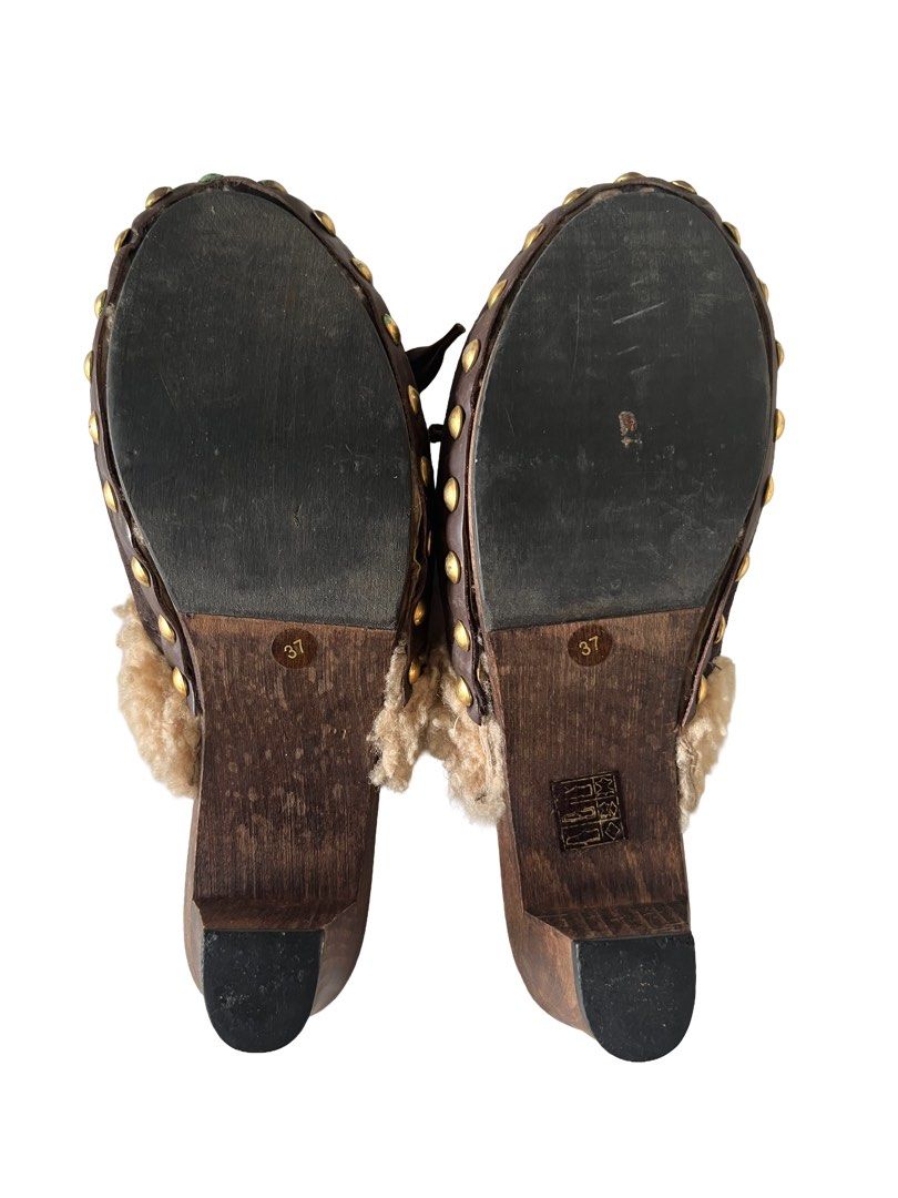 Miu Miu Brown Suede Shearling Clogs Mules Size 37 (Category: Loafers) located in Manila. Submitted by slavetorave (Listing ID 1449812857, Image 3). Description: - Luxurious brown suede mules - Soft shearling trim for ultimate comfort - Stylish wooden heel and sole - Elegant front lace-up detail with ribbon ties - Chic gold stud accents around the sole - Authentic Made in Italy craftsmanship - Size 37.