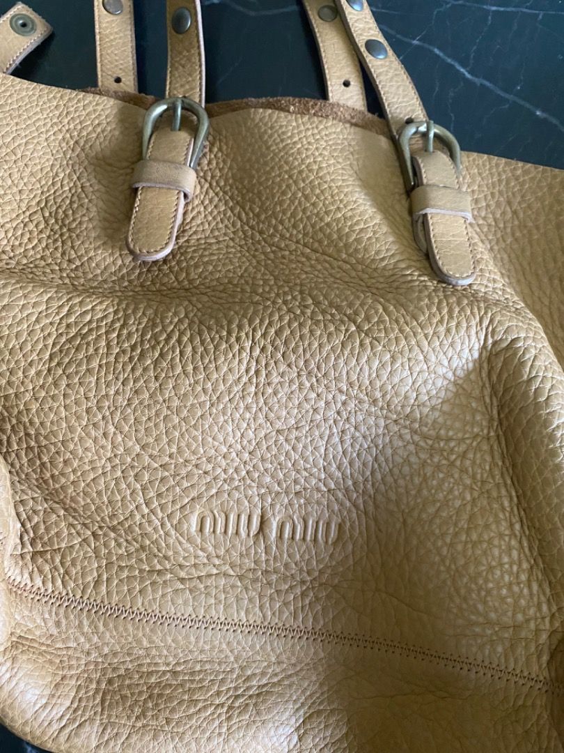 Miu Miu Leather Tote Bag (Category: Luxury Bags & Wallets) located in Manila. Submitted by haveago0dthrift (Listing ID 1449818668, Image 3). Description: - Authentic Miu Miu tan leather tote bag - Pebbled leather texture - Buckle details on straps - Interior zippered pocket - Minor signs of wear on leather and hardware - Made in Italy.