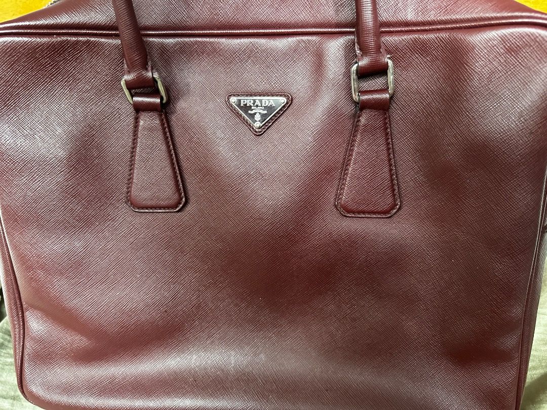 Prada Business Bag (Category: Luxury Bags & Wallets) located in Quezon City. Submitted by the_archive_luxe_ph (Listing ID 1449912097, Image 2). Description: A refined archive piece with presence — structured, functional, and unmistakably Pradå. —this structured business bag brings timeless sophistication to work and everyday carry. Material: Saffiano leather • Color: Deep Burgundy / Wine • Hardware: Silver-tone metal • Dimensions: approx. 40 × 28