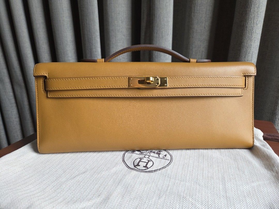 Preloved Hermes Kelly Cut Clutch (Category: Luxury Bags & Wallets) located in Quezon City. Submitted by shop.mar.go (Listing ID 1449785784, Image 1). Description: preloved Hermes Kelly Cut Clutch biscuit swift in gold hardware comes with dust bag and legit grails certificate stamp Y ( year 2020) has minor dirt marks, and signs of usage. but barely noticeable. perfect for events, evening bag, etc. perfect neutral color!.