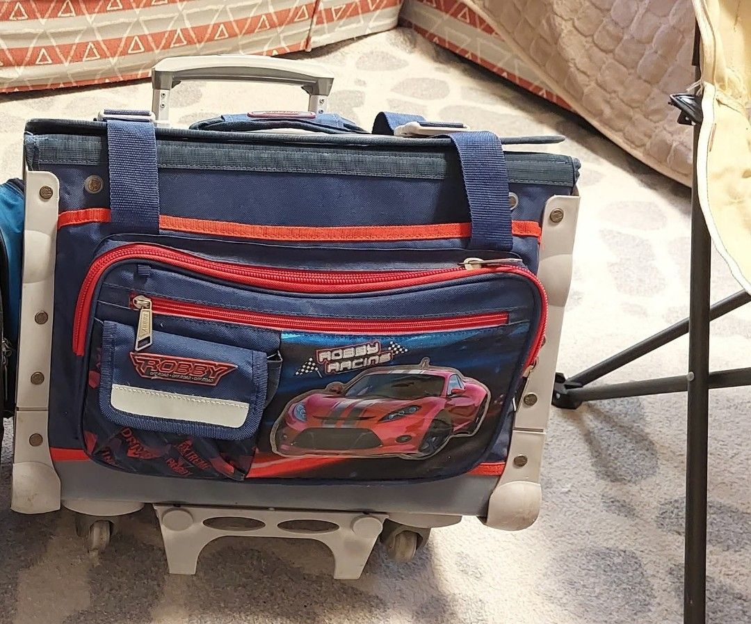 Robby rabbit trolley bag (Category: Babies & Kids Fashion) located in Quezon City. Submitted by jedcob011229 (Listing ID 1449763374, Image 1). Description: - robby rabbit trolley bag - Features a fun red race car graphic - Retractable handle and wheels for easy transport - Main compartment with zipper closure - Ideal for school or travel - Minor signs of wear on wheels and base - 1 school year lang nagamit..