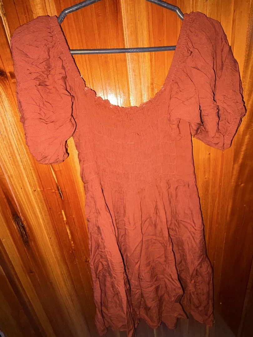 Rust Puff Sleeve Smocked Off-Shoulder Mini Dress (Category: Dresses) located in San Jose del Monte. Submitted by dcrishop (Listing ID 1449770369, Image 2). Description: - Cute rust-colored mini dress - Features puff sleeves - Smocked bodice for a comfortable fit - Flattering off-the-shoulder neckline - Unique crinkled fabric texture - Versatile for casual day or night out.