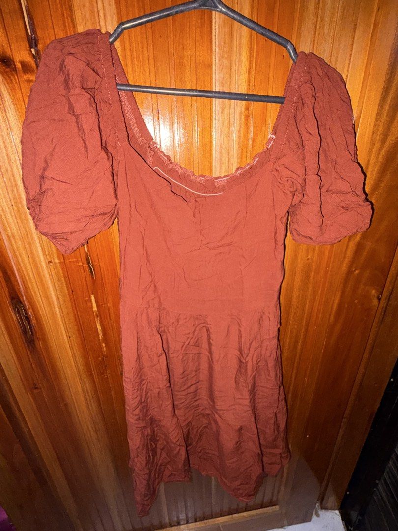 Rust Puff Sleeve Smocked Off-Shoulder Mini Dress (Category: Dresses) located in San Jose del Monte. Submitted by dcrishop (Listing ID 1449770369, Image 1). Description: - Cute rust-colored mini dress - Features puff sleeves - Smocked bodice for a comfortable fit - Flattering off-the-shoulder neckline - Unique crinkled fabric texture - Versatile for casual day or night out.