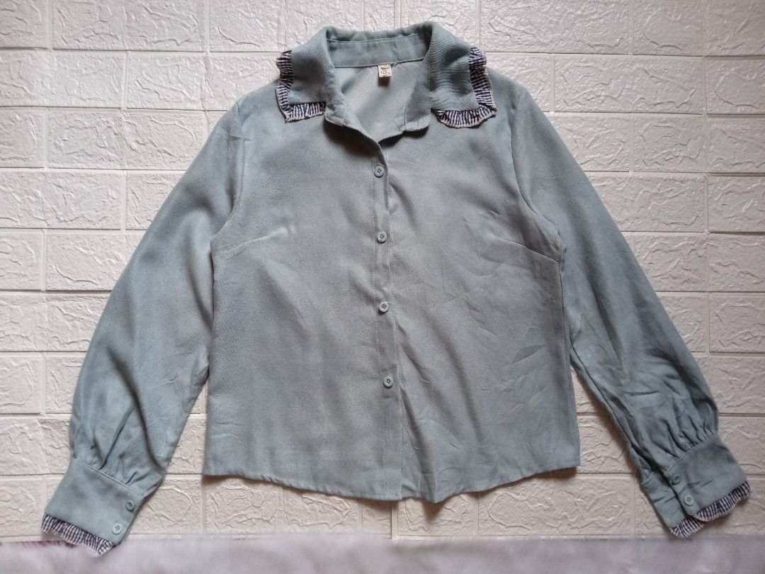 Sage Green Soft-Brushed Blouse with Navy Gingham Ruffle Trim (Category: Longsleeves) located in Los Banos. Submitted by wise-fox27 (Listing ID 1449835015, Image 1). Description: - Fall in love with the textures of this unique sage green/gray-blue shirt. - Made from a super soft, brushed suede-like fabric - Elevated by sweet navy blue and white gingham ruffled trims along the collar and inside the cuffs. - A perfect blend of cozy and cute! - Style