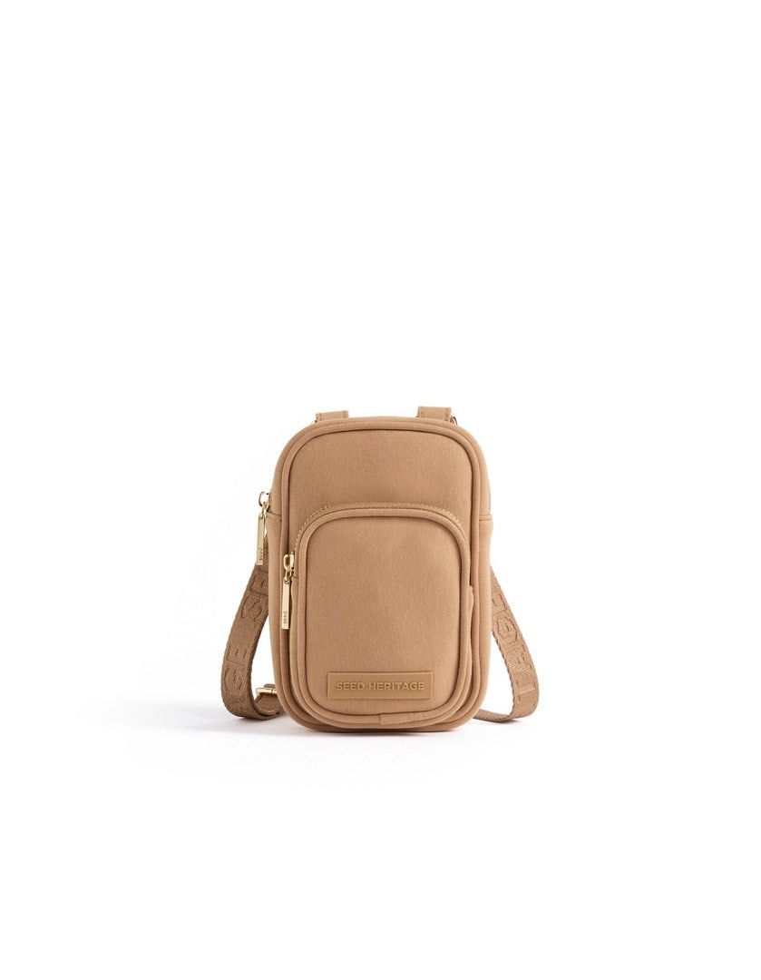 SEED HERITAGE Tan Jersey Crossbody Bag (Category: Cross-body Bags) located in Manila. Submitted by decluterrrr (Listing ID 1449778140, Image 1). Description: Dimensions: 11.5 x 18 x 4.5cm Fabrication: Body: 70% Cotton, 30% Polyurethane Compact and ideal for keeping your essentials at hand, this bag features a logo-branded crossbody strap, an internal slip pocket, an external front pocket, and zip closures. Features: Crossbody strap with logo Zip 