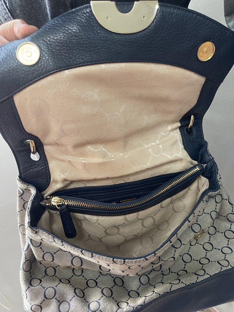 Oroton Navy Leather & Monogram Shoulder Bag (Category: Luxury Bags & Wallets) located in Las Pinas. Submitted by a_crs51 (Listing ID 1449803610, Image 3). Description: - Navy blue leather and canvas shoulder bag - Features the iconic Smythson monogram pattern - Elegant gold hardware detail on the front flap - Interior zip pocket and card slots for organization - Adjustable shoulder strap for comfortable wear - Ideal everyday bag for style and pra