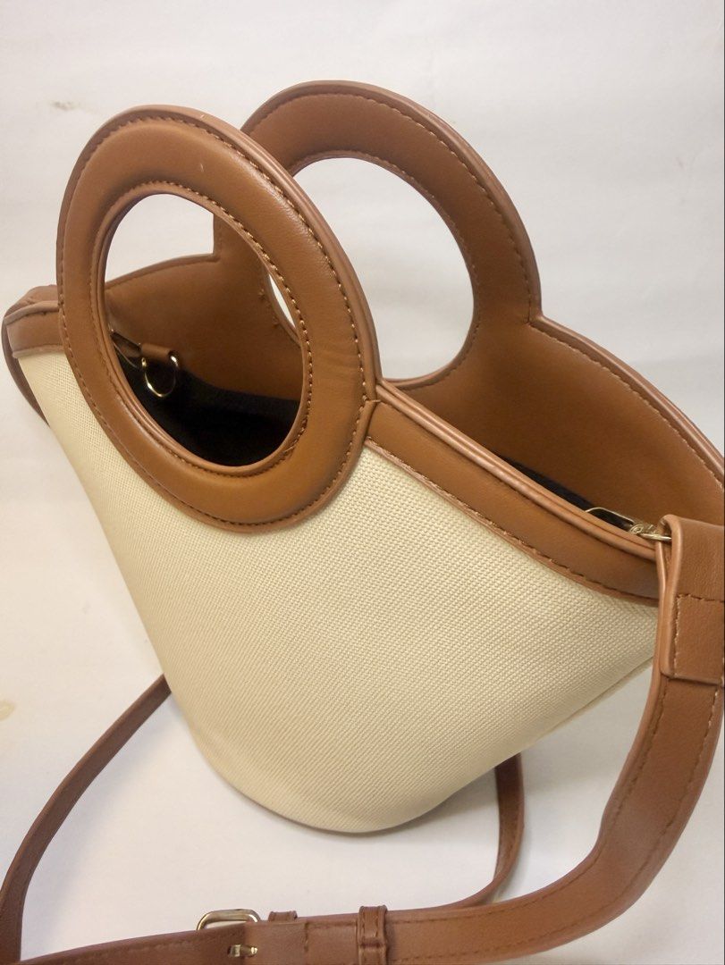 Tan and Cream Bucket Bag (Category: Purses & Pouches) located in Mandaluyong City. Submitted by cherryspicks (Listing ID 1449914500, Image 2). Description: This is a well made bag and can stand upright r. It also has feet! The tan is a good color. There is a detachable longer strap. There is also a removable tan pouch . .