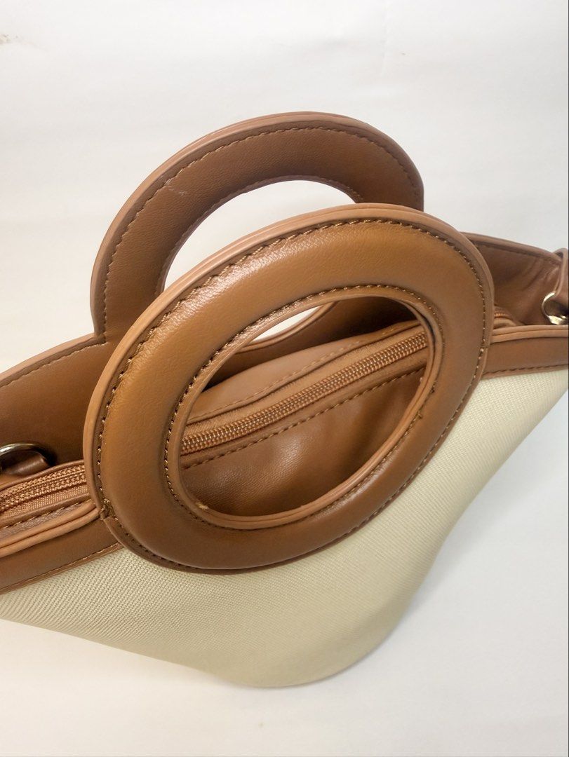Tan and Cream Bucket Bag (Category: Purses & Pouches) located in Mandaluyong City. Submitted by cherryspicks (Listing ID 1449914500, Image 3). Description: This is a well made bag and can stand upright r. It also has feet! The tan is a good color. There is a detachable longer strap. There is also a removable tan pouch . .