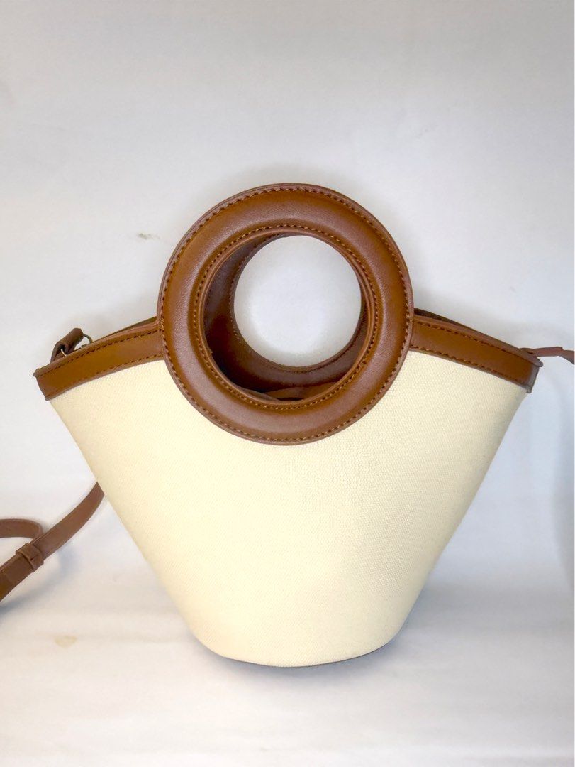 Tan and Cream Bucket Bag (Category: Purses & Pouches) located in Mandaluyong City. Submitted by cherryspicks (Listing ID 1449914500, Image 1). Description: This is a well made bag and can stand upright r. It also has feet! The tan is a good color. There is a detachable longer strap. There is also a removable tan pouch . .