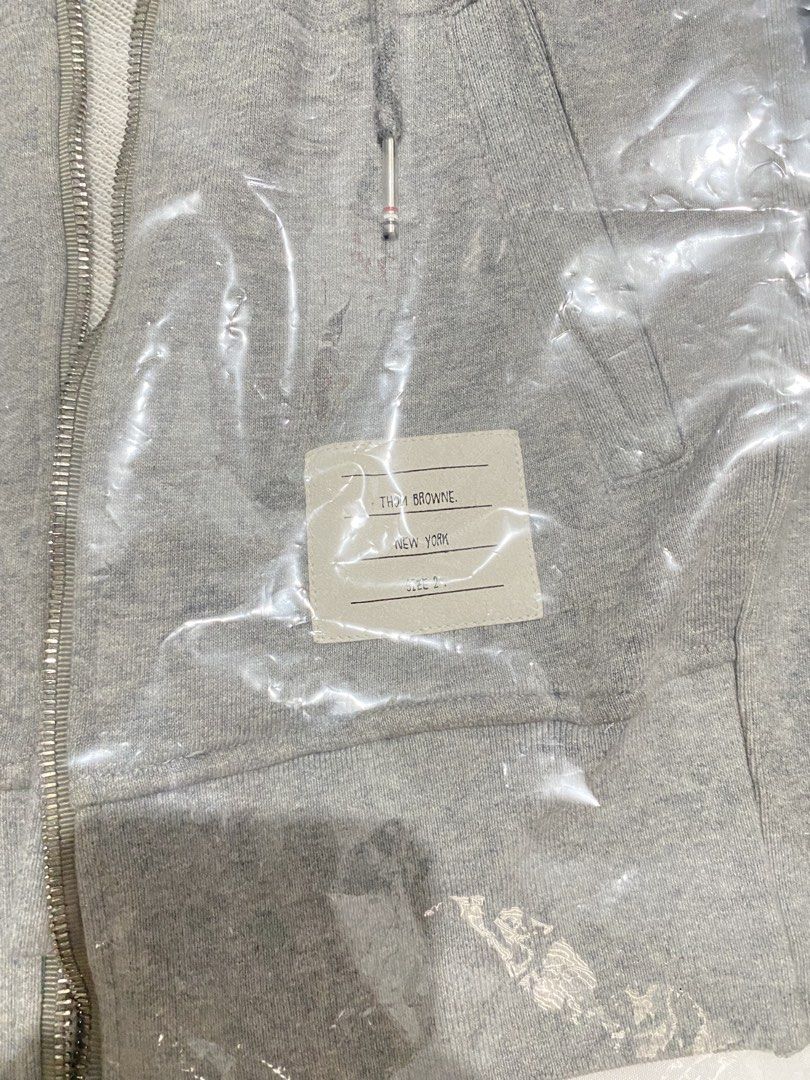 Thom Browne 4-Bar Zip-Up Hoodie (Category: Coats, Jackets and Outerwear) located in Cavite. Submitted by JandyLou (Listing ID 1449812660, Image 2). Description: Carousell Listings Title: Thom Browne 4-bar zip-up hoodie Grey Size: Medium Mens Size 2 Condition: Like New (Color may vary due to lighting) Price: Php 2,000 Flaws: No Flaws Payment Methods: Payment first via Gcash Delivery Options (shoulder by buyer): Lalamove, Lbc or J&T delivery. NO CA