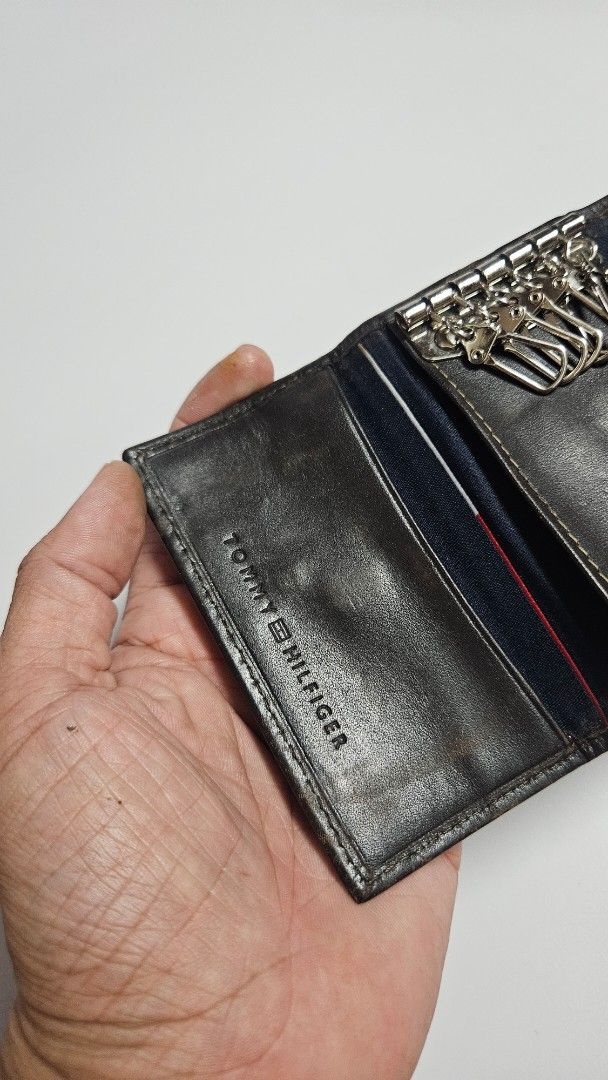 Tommy Hilfiger Leather Key Holder Wallet (Category: Wallets & Card holders) located in Alfonso. Submitted by jbcamet (Listing ID 1449852405, Image 3). Description: - Authentic Tommy Hilfiger key holder - Made from premium dark brown leather - Features multiple key hooks for organization - Includes a convenient small slot for cards or cash - Secure snap button closure - Classic and timeless design.