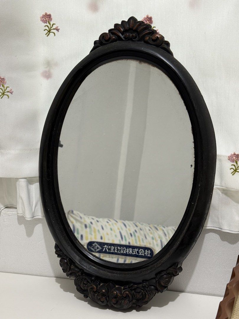 Vintage Oval Mirror with Ornate Dark Hard Plastic Frame (Category: Mirrors) located in Mandaluyong City. Submitted by toby.yumi (Listing ID 1449757403, Image 1). Description: Vintage oval mirror with a dark, ornate hard plastic frame. Features decorative carvings and a Japanese label. Perfect for vanity or entryway..