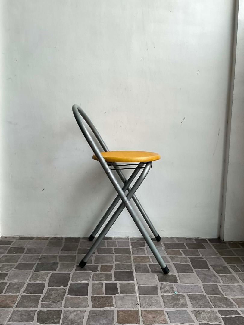 Wooden Round Seat Folding Stool (Category: Chairs) located in Quezon City. Submitted by thriftjunks (Listing ID 1449760386, Image 2). Description: - Compact folding stool - Bright yellow seat - Sturdy grey metal frame - Easy to fold and store - Ideal for extra seating - Suitable for indoor and outdoor use.