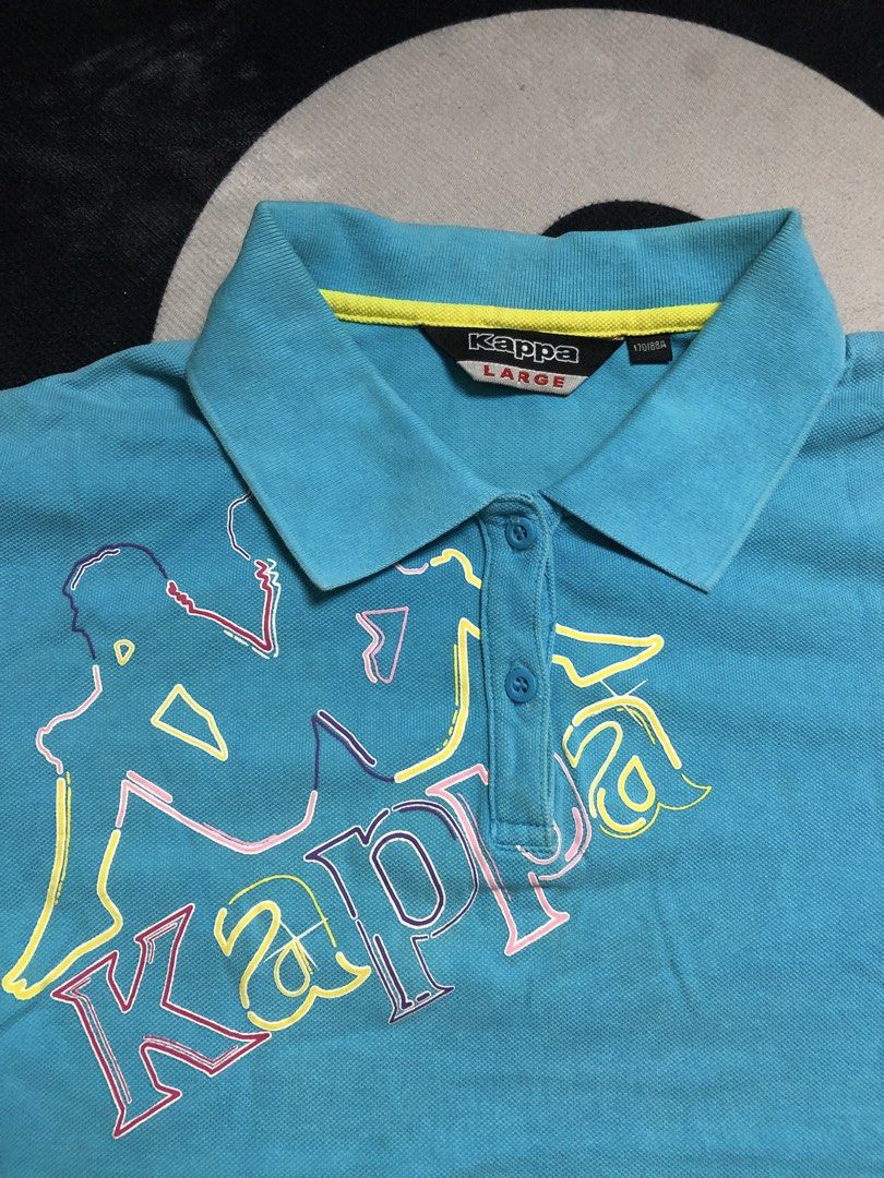 Y2K Kappa Blue Polo Shirt (Category: Shirts) located in Cavite. Submitted by secondhandco.archive552 (Listing ID 1449845605, Image 3). Description: Y2K FITTED POLO KAPPA (womens) 📌W(17) L(22) 📌ISSUE: N/A 📌COLOR RATE: 9/10 📌CONDITION: 9/10 - Blue Kappa polo shirt - Iconic Kappa logo across the chest (yellow, pink, purple outlines) - Short sleeves with collared neckline and button closure - Material: 100% Cotton.
