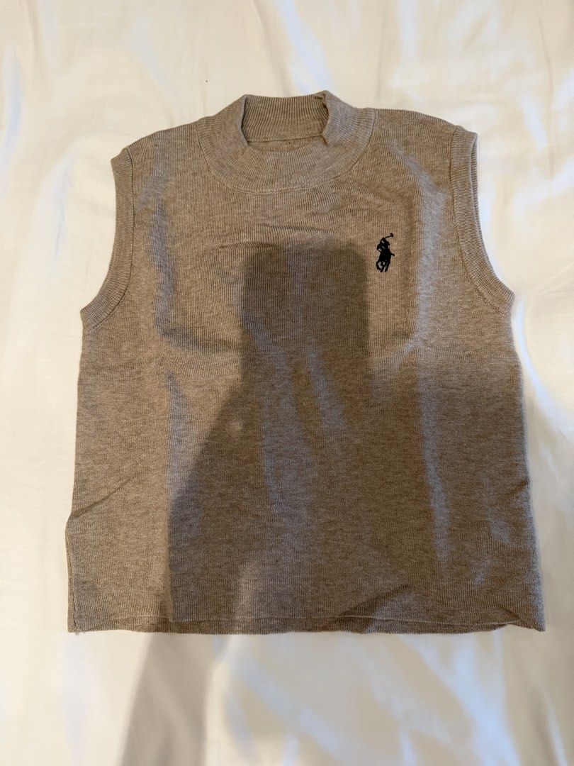 Brown Sleevesless Top （分類：背心）位於 Hong Kong。 由 janellasteffie 提交（商品編號 1449954052，圖片 2）。簡介： Hey there! 👋 Up for grabs is this super chic sleeveless top in a lovely shade of brown. It's got a stylish mock neck and a cute little embroidered logo on the chest – perfect for adding a touch of effortless cool to your outfit. This is a free size piece, so it should fit most people comfortably. Grab it before it's gone!。