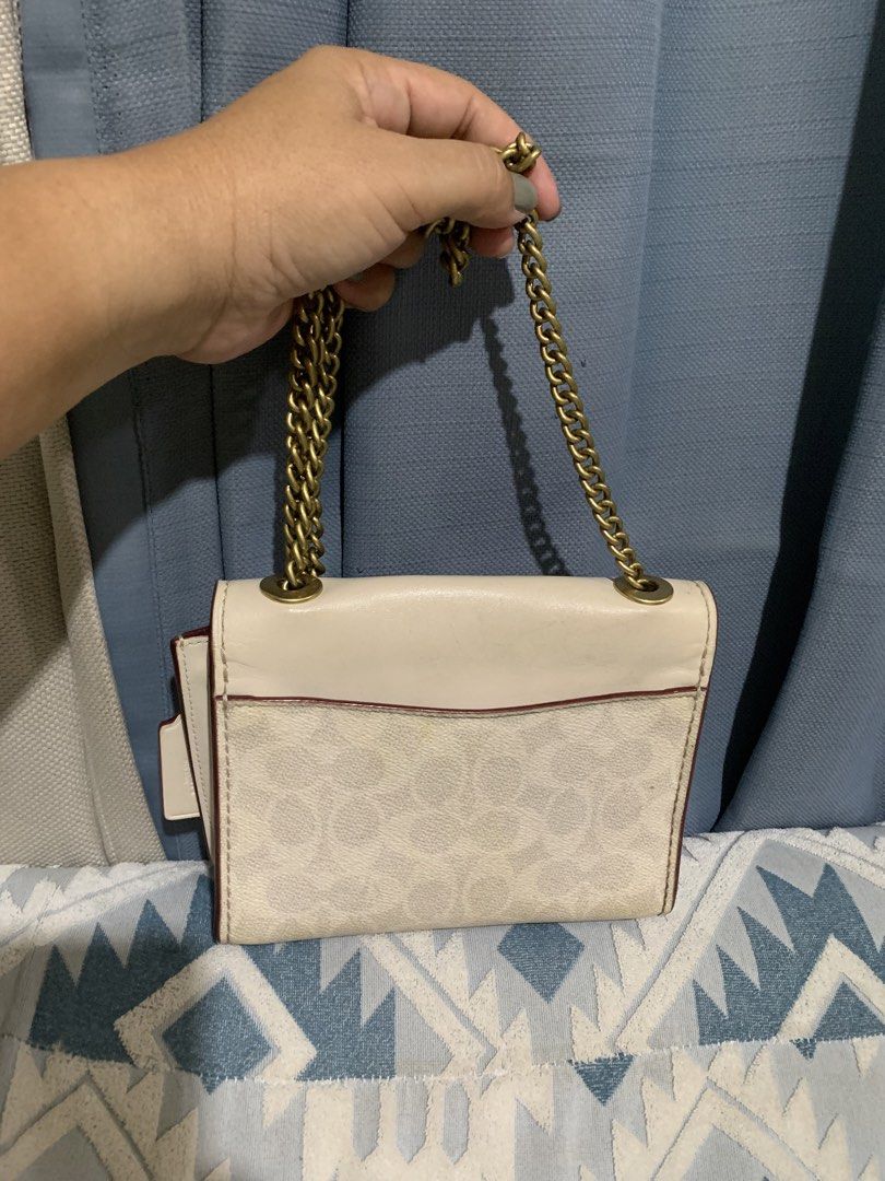 Coach Floral Turnlock Shoulder Bag Cream Monogram (Category: Luxury Bags & Wallets) located in Liloan. Submitted by jinalyns (Listing ID 1450044975, Image 2). Description: Coach shoulder bag in cream with signature monogram print. Features a gold-tone floral turnlock closure. The chain strap is also gold-tone. Comes with a Coach leather hangtag. Interior has a burgundy lining. Great for casual outings..