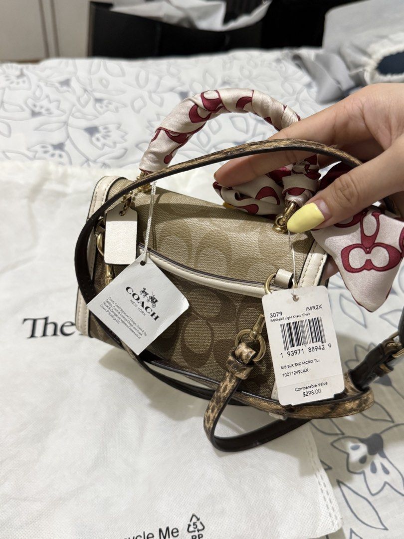 Coach Signature Canvas Micro Mini Bag with Scarf (Category: Luxury Bags & Wallets) located in Angono. Submitted by xxxallaboutbagsxxx (Listing ID 1450003431, Image 2). Description: - Authentic Coach Signature Canvas Micro Mini Bag - Comes with a cute scarf tied to the handle - Includes a crossbody strap - Interior has a small pocket - Original tags still attached - Purchased from The Real Real.
