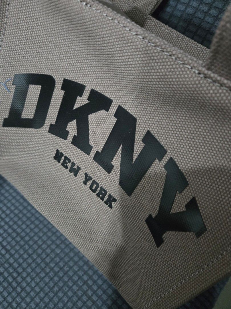 DKNY New York Canvas Tote Bag (Category: Tote Bags) located in Manila. Submitted by opssyyyy (Listing ID 1450035726, Image 2). Description: - Brand: DKNY New York - Type: Canvas Tote Bag - Color: Tan with black lettering - Features: Top handles, detachable shoulder strap, zipper closure - Origin: Made in Cambodia - Ideal for: Everyday use, travel.