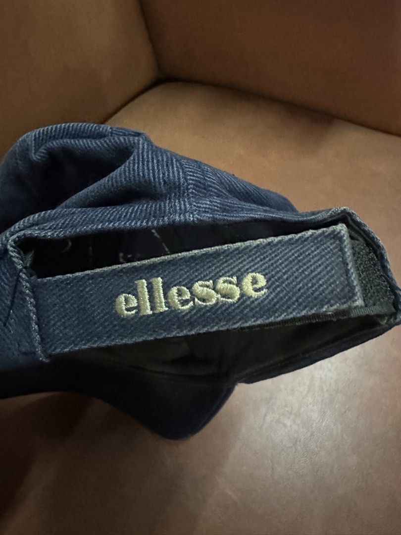 Ellesse Navy Blue Washed Cotton Baseball Cap (Category: Caps & Hats) located in Manila. Submitted by clamchowder19 (Listing ID 1450038327, Image 2). Description: - Navy blue Ellesse cap - Made from washed cotton material - Features an adjustable strap at the back for a custom fit - Embroidered Ellesse logo on the front - Perfect for everyday casual wear - Shows some signs of wear, particularly on the brim and sweatband.