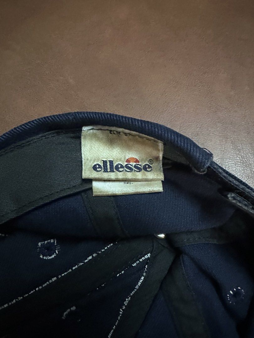 Ellesse Navy Blue Washed Cotton Baseball Cap (Category: Caps & Hats) located in Manila. Submitted by clamchowder19 (Listing ID 1450038327, Image 3). Description: - Navy blue Ellesse cap - Made from washed cotton material - Features an adjustable strap at the back for a custom fit - Embroidered Ellesse logo on the front - Perfect for everyday casual wear - Shows some signs of wear, particularly on the brim and sweatband.