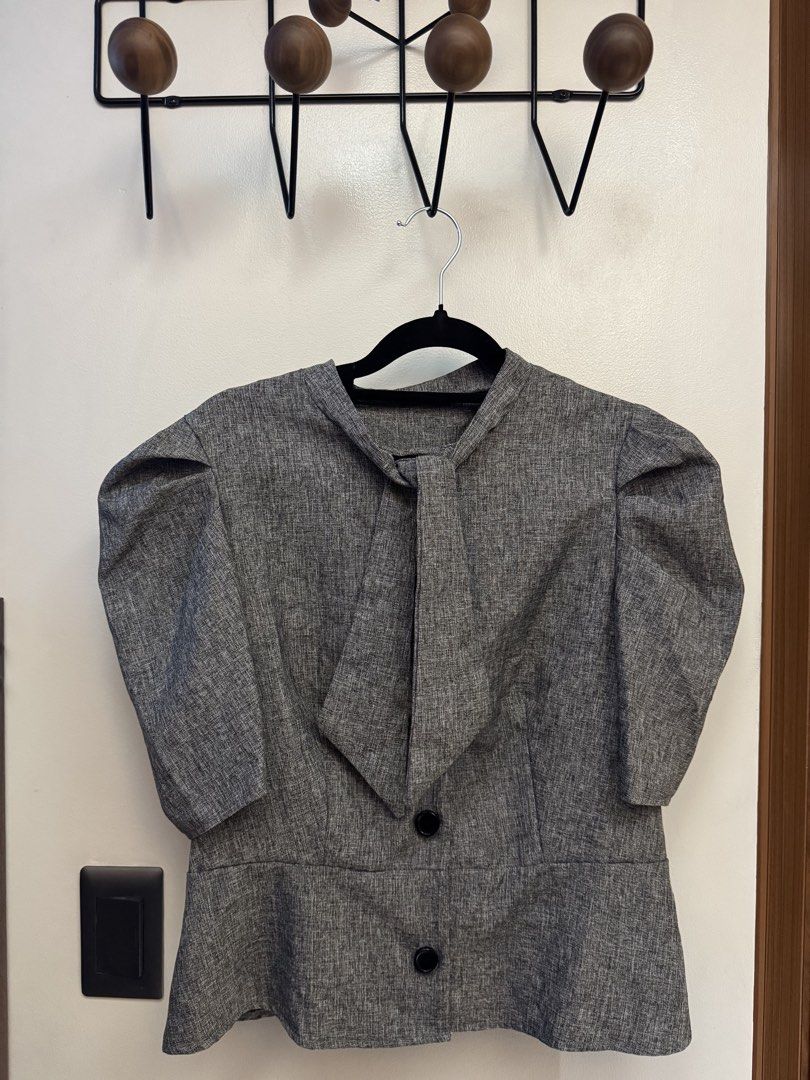 Grey Textured Puff Sleeve Blouse with Tie Neck (Category: Blouses) located in Makati City. Submitted by reenita (Listing ID 1450080936, Image 2). Description: - Stylish grey textured blouse - Features elegant puff sleeves - Chic tie neck detail - Front closure with two black buttons - Flattering peplum hem - Made from 100% polyester - Easy care: Machine washable on gentle cycle - Size: Large (L).