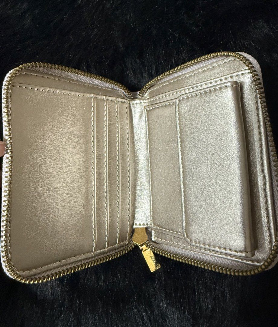 Guess Est 1981 White Zip Around Wallet (Category: Wallets & Card holders) located in Bacoor. Submitted by cielo1985 (Listing ID 1450096214, Image 2). Description: - White Guess wallet - Gold zipper closure - Interior card slots - Small inner compartment - Gold Guess logo on front - Approximate dimensions: 4.5 inches (width) x 3.5 inches (height) - Ideal for keeping your essentials neatly organized.