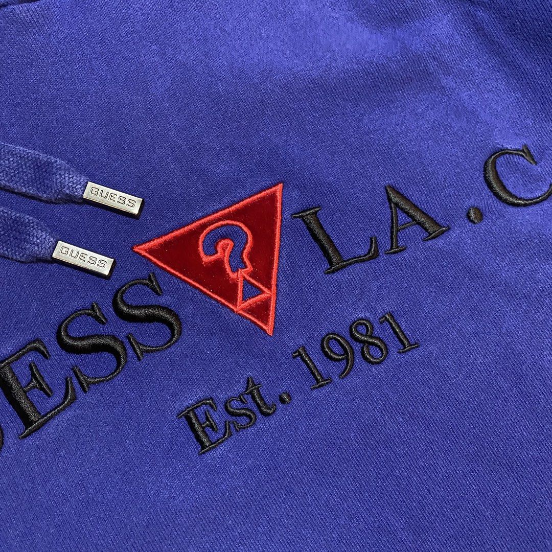 Guess LA Est. 1981 Blue Hoodie (Category: Hoodies) located in Dipolog. Submitted by dionato (Listing ID 1449998360, Image 3). Description: - Blue Guess hoodie - Features 'LA Est. 1981' graphic - Front pocket for convenience - Adjustable drawstring hood with branded metal tips - Embroidered Guess logo on the chest - Ideal for everyday casual wear.