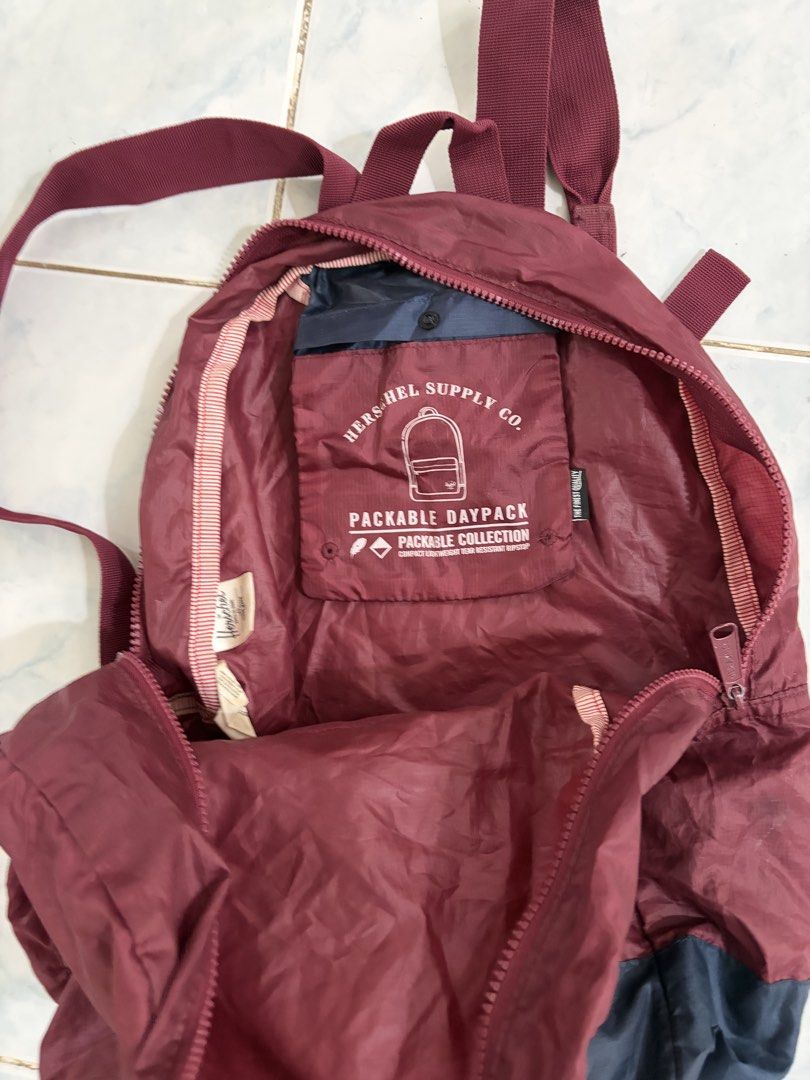 Herschel Supply Co. Packable Daypack Backpack (Category: Backpacks) located in Santa Rosa. Submitted by mm024 (Listing ID 1450078148, Image 2). Description: - Maroon and navy Herschel Packable Daypack - Folds up small for easy storage - Ideal for travel or everyday use - Includes a front zip pocket and main compartment - Adjustable straps for a comfortable fit - Made with lightweight material Issues: Small pocket in front has a hole but can be se