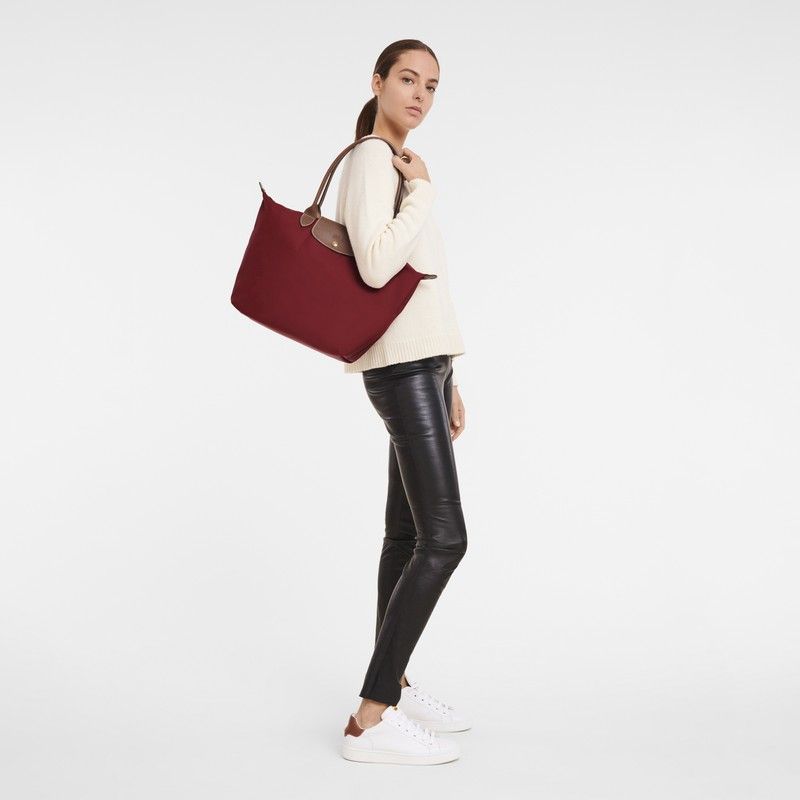 Longchamp Le Pliage Tote Bag Red Large (Category: Luxury Bags & Wallets) located in Gapan. Submitted by mdcollection.ph (Listing ID 1450082631, Image 3). Description: - Classic Longchamp tote bag - Rich burgundy color - Durable nylon with genuine leather handles - Folds flat for convenient storage - Ideal for everyday use, work, or travel - Generous interior space.