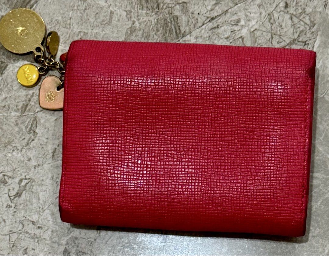 MCM Hot Pink Leather Medium Tri-Fold Wallet with Charms (Category: Luxury Bags & Wallets) located in Cavite. Submitted by edendardar07 (Listing ID 1449964011, Image 2). Description: - Authentic MCM wallet in vibrant pink - Textured leather exterior with multiple MCM logos - Adorable charm set included (lion, heart, etc.) - Interior: Multiple card slots and clear ID window - Secure snap closure.