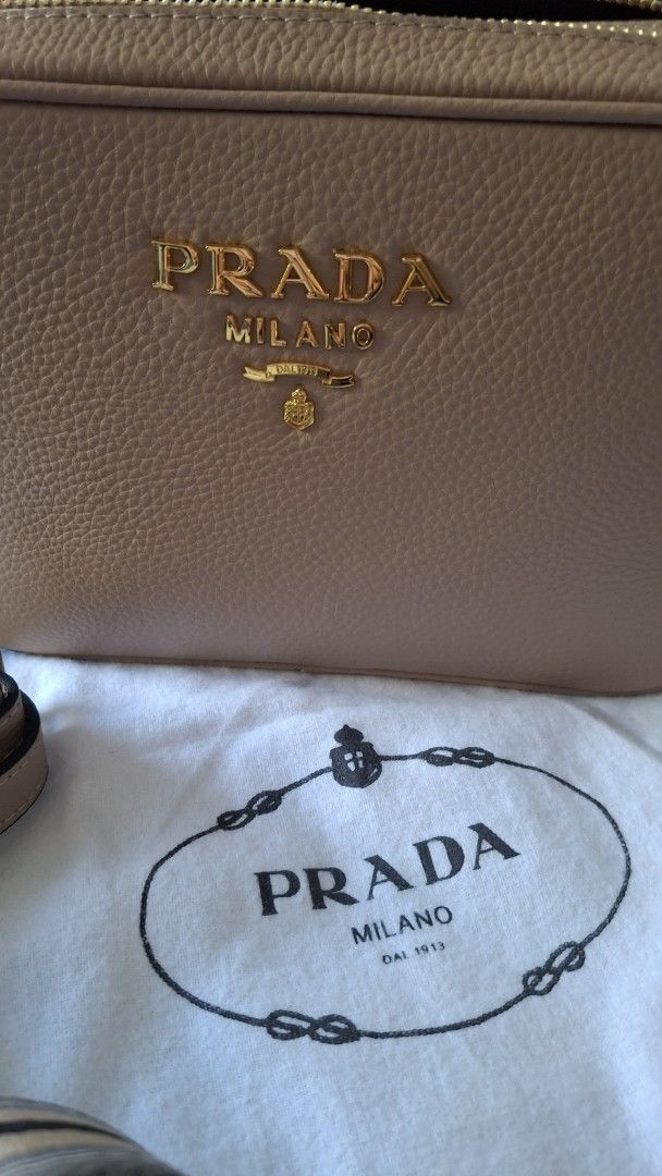 Prada Camera Bag Beige Leather Gold Hardware (Category: Luxury Bags & Wallets) located in Angono. Submitted by bagamania (Listing ID 1450034205, Image 2). Description: - Beige Prada Vitello Phenix Camera Bag - Crafted from premium textured leather - Elegant gold-tone hardware - Comes with Prada dust bag - Includes two versatile straps: a classic plain leather strap and a stylish striped fabric strap - Interior features signature Prada logo lining