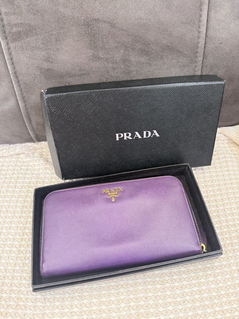 Prada Saffiano zip around leather (Category: Luxury Bags & Wallets) located in Angeles City. Submitted by bagpriceinfiniteluck (Listing ID 1449987120, Image 2). Description: Preloved 8/10 condition with fadings. Selling Super low price! 💯Prada womens zip around saffiano leather wallet in dinstinct purple hue, characterized by its cross hatch textured leather gold toned metal lettering logo and matching signature prada gift box✨ ON HAND PH🇵🇭🇵�