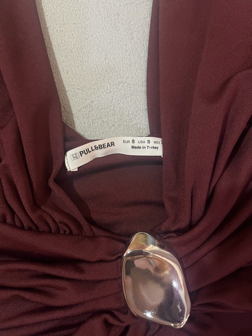 Pull & Bear Bodysuit Size S (Category: Others Tops) located in Manila. Submitted by cesca28 (Listing ID 1449965515, Image 2). Description: Maroon Pull & Bear bodysuit, size S. Features a deep V-neck with silver accent and ruched sides. .