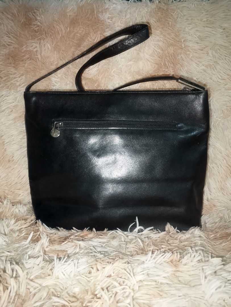 RENOMA Black Leather Shoulder Bag with Embossed Logo (Category: Shoulder Bags) located in Manila. Submitted by triple_r.shop.ph (Listing ID 1450048968, Image 2). Description: - Genuine black leather shoulder bag - Elegant embossed logo pattern on the front - Secure zipper closure located on the back - Chic silver hardware detail on the strap - Protective studs on the bottom for durability - Ideal size for everyday use and carrying essentials.