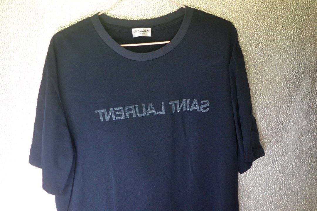 Saint Laurent Reversed Tshirt (Category: Luxury Apparel) located in Lugus. Submitted by itsluxurythings (Listing ID 1450042450, Image 2). Description: - Saint Laurent Paris T-shirt - Size: Large - Dimensions: w21.5 L27 - Color: Midnight Blue - Condition: Excellent condition look brandnew - Style: Versatile basic tee, ideal for everyday styling PM me for faster Transaction Payment via Mobile Banking or via Gcash .