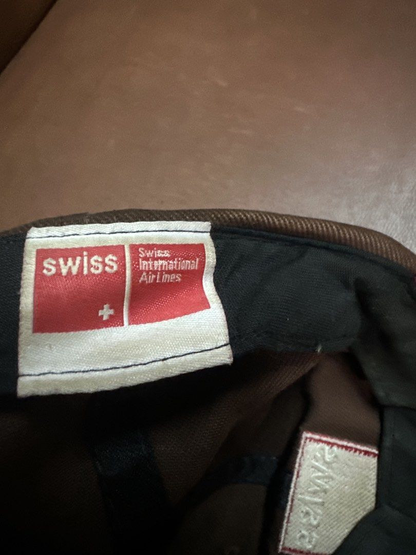 Swiss International Airlines Brown Cap (Category: Caps & Hats) located in Manila. Submitted by clamchowder19 (Listing ID 1450037659, Image 3). Description: - Brown baseball cap from Swiss International Airlines - Features the iconic Swiss logo on the front - Adjustable strap with a metal buckle for a custom fit - Perfect for aviation enthusiasts and Swiss fans.