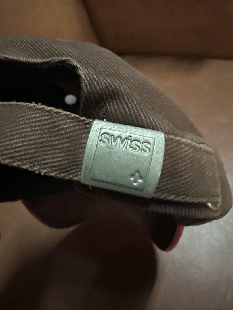 Swiss International Airlines Brown Cap (Category: Caps & Hats) located in Manila. Submitted by clamchowder19 (Listing ID 1450037659, Image 2). Description: - Brown baseball cap from Swiss International Airlines - Features the iconic Swiss logo on the front - Adjustable strap with a metal buckle for a custom fit - Perfect for aviation enthusiasts and Swiss fans.