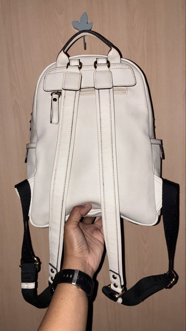 White Studded Backpack with 'E' Initial (Category: Backpacks) located in Placer. Submitted by talaalond61563 (Listing ID 1449954381, Image 3). Description: - E-LAND - Stylish white backpack with eye-catching gold studs. - Convenient front zip pocket and side pockets for organization. - Features a unique 'E' detail on the front. - Adjustable black straps with white stripes for a comfortable fit. - Ideal for everyday use, school, or travel..