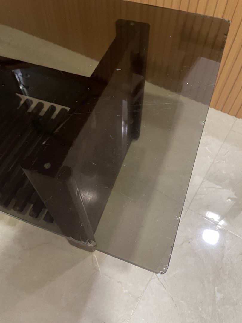 Wooden and Glass Center Table (Category: Tables & Sets) located in Manila. Submitted by shaneacara (Listing ID 1449957565, Image 2). Description: - Rectangular coffee table - Dark wood base with slatted shelf for storage - Glass top - Scratches and chips on glass edges but rest assured that glass is thick and no other flaws.