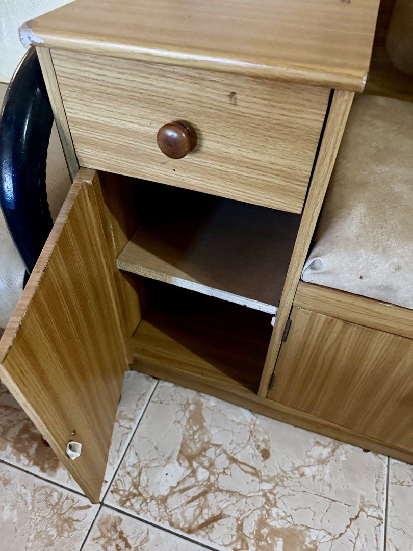 Wooden Storage Bench with Side Table and Seat (Category: Chairs) located in Quezon City. Submitted by eleventwelveph (Listing ID 1449977480, Image 2). Description: - Versatile wooden storage bench with integrated side table. - Ample storage: drawer and cabinet space below the seat. - Comfortable light beige cushioned seat. - Note: Small tear on the cushion. - Side table includes its own drawer and cabinet door. - Ideal for entryway organization o