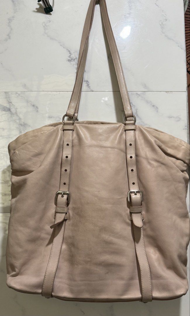 Authentic Prada Nappa leather New Look tote (Category: Luxury Bags & Wallets) located in Manila. Submitted by deoksun (Listing ID 1450248050, Image 2). Description: Authentic Negotiable nappa leather body clochette adjustable flat leather straps interior zip and slip pockets peach Condition: GOOD. This previously owned and used item is in good condition with minimal signs of use. Please refer to the photos on this product page for a detailed view