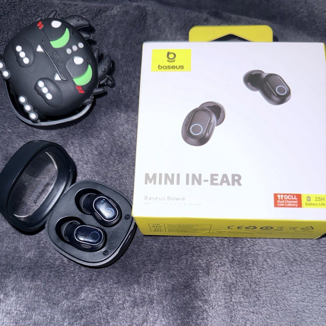 Baseus Bowie Mini In-Ear Wireless Earbuds with Case (Category: Earphones) located in Muntinlupa City. Submitted by han2far (Listing ID 1450273106, Image 2). Description: - Baseus Bowie Mini In-Ear Wireless Earbuds - Color: Black - Includes charging case - Comes with a cute monster-themed silicone case cover - Battery life: Up to 25 hours - Features low latency for seamless audio experience.