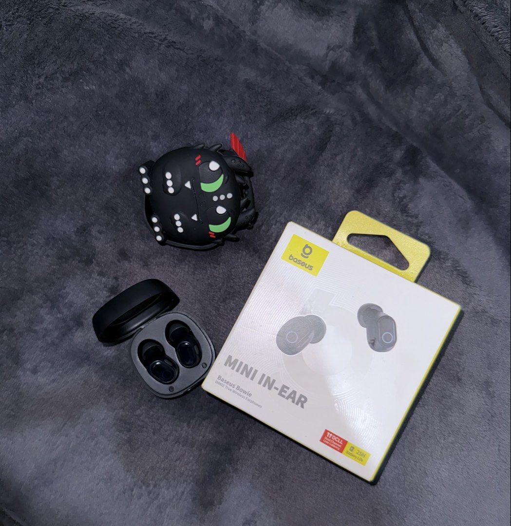 Baseus Bowie Mini In-Ear Wireless Earbuds with Case (Category: Earphones) located in Muntinlupa City. Submitted by han2far (Listing ID 1450273106, Image 1). Description: - Baseus Bowie Mini In-Ear Wireless Earbuds - Color: Black - Includes charging case - Comes with a cute monster-themed silicone case cover - Battery life: Up to 25 hours - Features low latency for seamless audio experience.