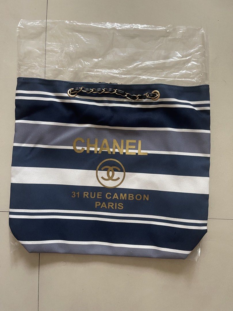 Chanel Striped Tote Bag (Category: Luxury Bags & Wallets) located in Quezon City. Submitted by kingcurator (Listing ID 1443209080, Image 3). Description: - Classic Chanel tote bag - Horizontal stripes in navy, grey, and white - Gold 'CHANEL' logo and '31 RUE CAMBON PARIS' text - Elegant chain detail on handles - Spacious interior for all your essentials - Ideal for everyday use or travel.