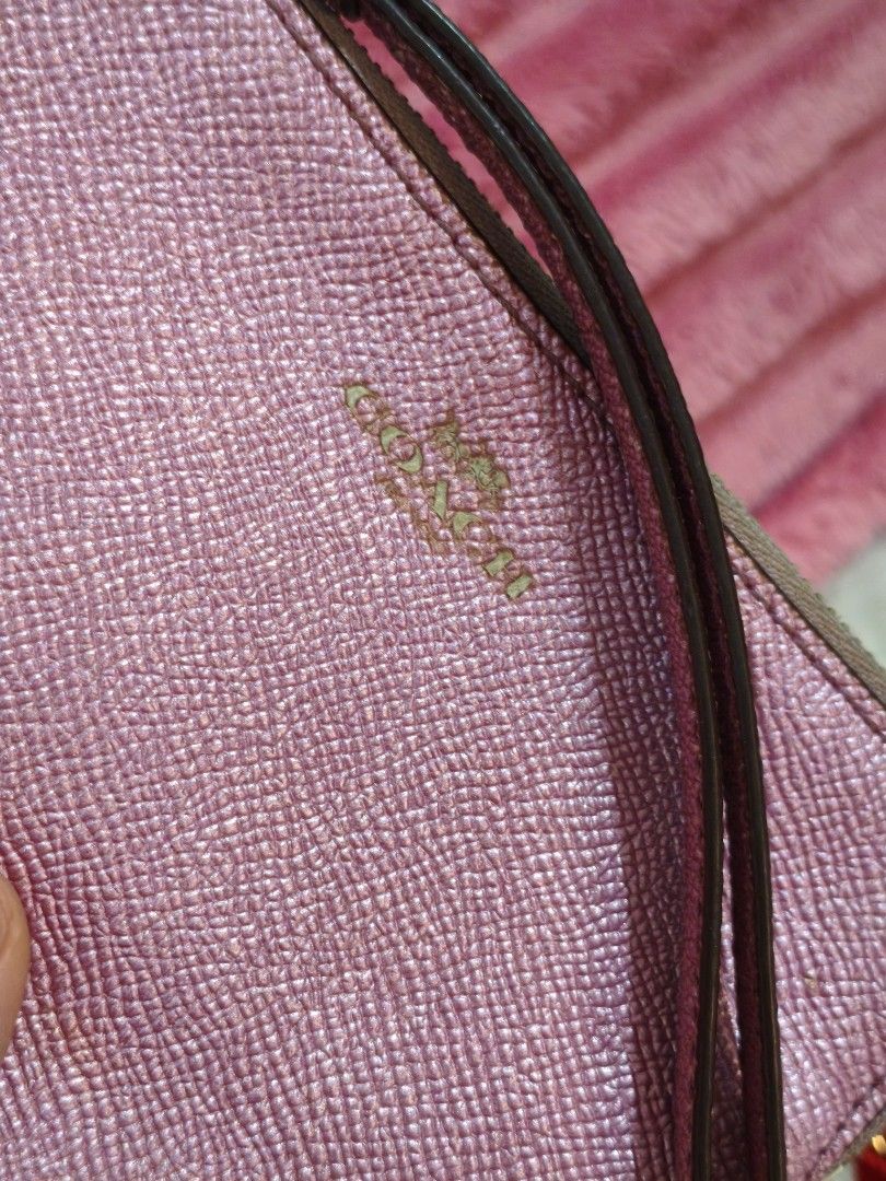Coach Pink Metallic Leather Wristlet Pouch (Category: Luxury Bags & Wallets) located in Imus. Submitted by umusthave23 (Listing ID 1450187962, Image 2). Description: - Coach wristlet in a pretty pink metallic leather. - Features a convenient wrist strap. - Interior includes card slots for organization. - Perfect for carrying your daily essentials. - Shows some signs of wear (inside and out), but remains fully functional..