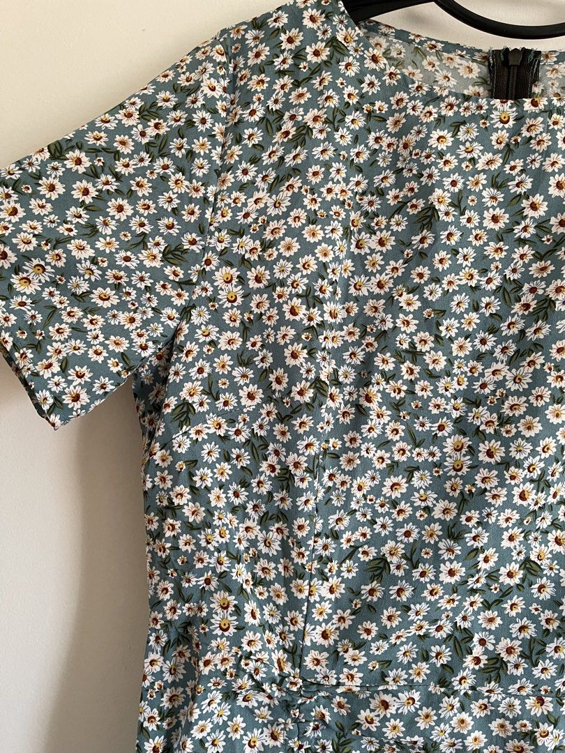 Daisy Print Ruched Midi Dress (Category: Dresses) located in Paombong. Submitted by declutteredbychee_ (Listing ID 1450227069, Image 3). Description: - Green midi dress with a charming white daisy print. - Features short sleeves for comfortable wear. - Flattering ruched detail along the side with a tie at the hem. - Stylish ruffle hemline. - Estimated size: Large (L). - Ideal for casual occasions and everyday style..