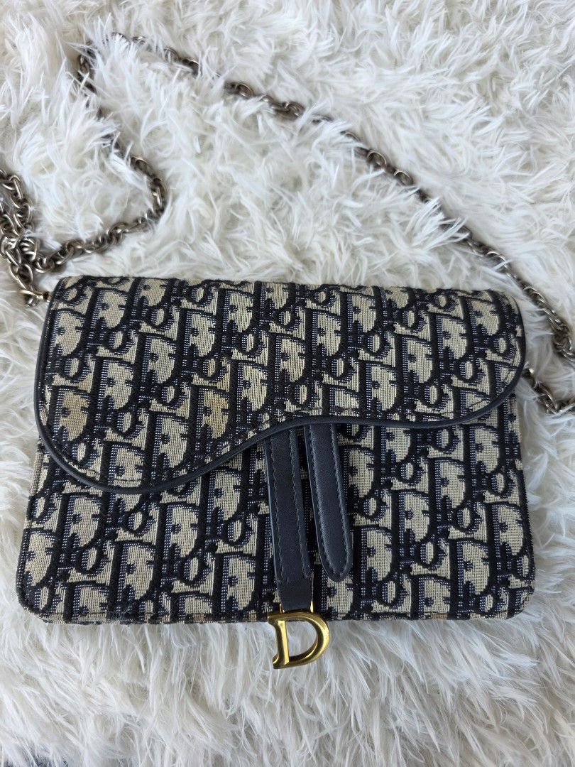 Dior Saddle Wallet on Chain Oblique Canvas (Category: Luxury Bags & Wallets) located in Lemery. Submitted by venus23 (Listing ID 1450209355, Image 1). Description: - Dior Saddle Wallet on Chain - Iconic Dior Oblique canvas - Elegant gold hardware with D-ring detail - Secure zipper closure - Dior underzip - Detachable chain strap for shoulder or crossbody styling - Compact and perfect for carrying your essentials -Replacement Sling.
