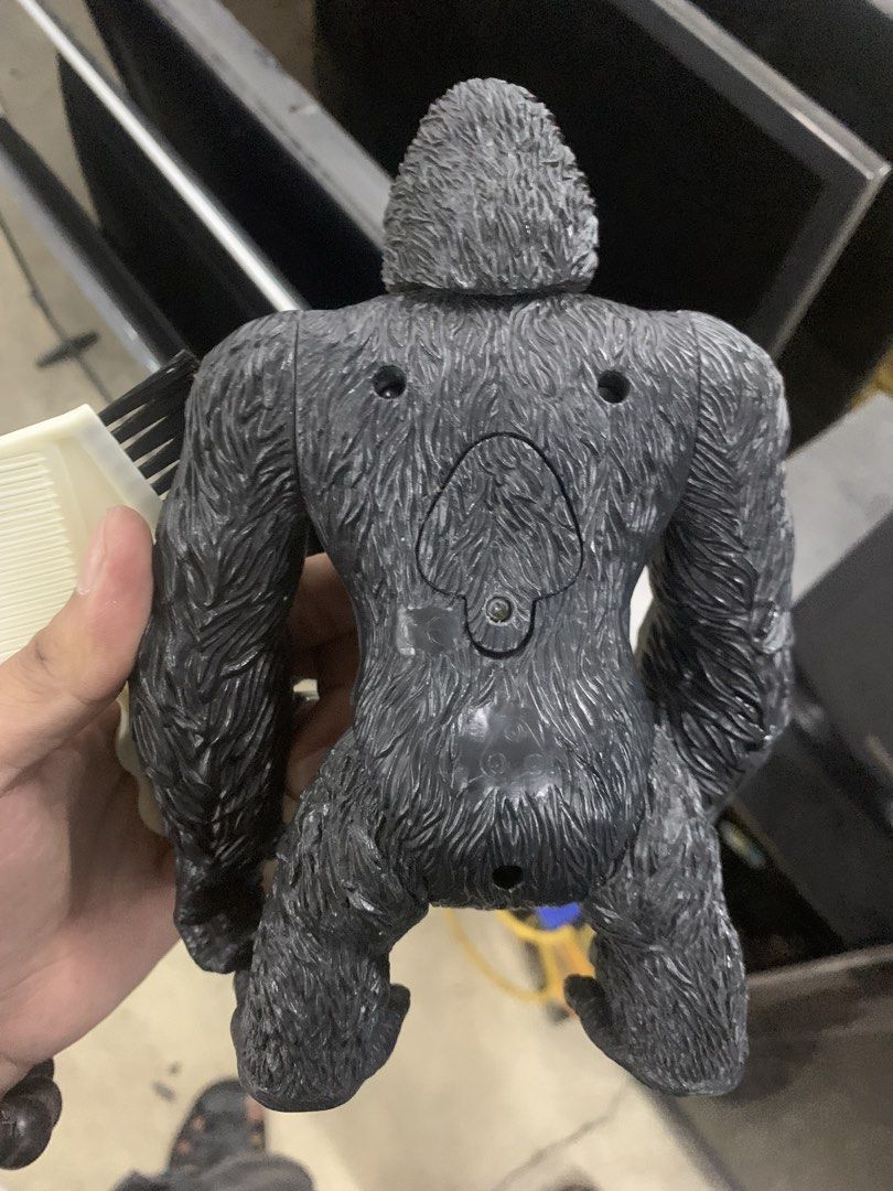 King Kong Action Figure Toy (Category: Figurines & Statues) located in Manila. Submitted by 0thrift_n_isaw (Listing ID 1450164556, Image 2). Description: - Dark grey King Kong action figure - Textured fur details for a realistic look - Fully articulated joints for dynamic posing - Detailed fingers and toes on feet - Small circular indentation on back (possibly for stand) - Visible markings on the bottom of one foot.