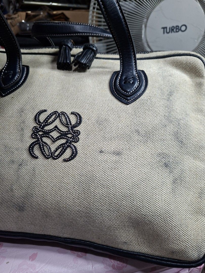 Loewe Canvas Tote Bag with Leather Trim (Category: Luxury Bags & Wallets) located in Lucena. Submitted by dai_suki (Listing ID 1450320409, Image 2). Description: - Loewe canvas tote bag - Navy leather trim and handles - Embroidered Loewe anagram on front - Canvas exterior has some marks and stains - Spacious interior - Ideal for everyday use.