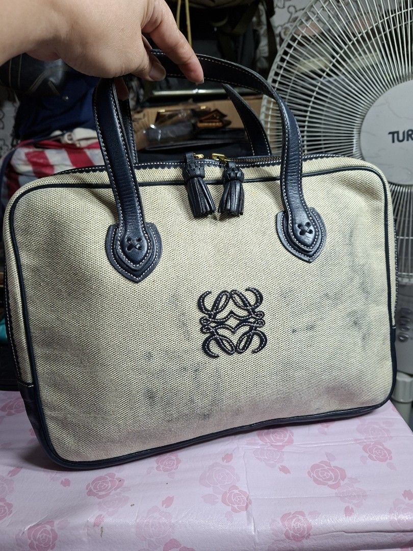 Loewe Canvas Tote Bag with Leather Trim (Category: Luxury Bags & Wallets) located in Lucena. Submitted by dai_suki (Listing ID 1450320409, Image 1). Description: - Loewe canvas tote bag - Navy leather trim and handles - Embroidered Loewe anagram on front - Canvas exterior has some marks and stains - Spacious interior - Ideal for everyday use.